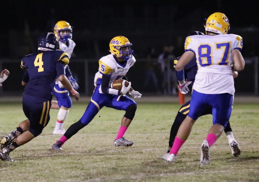 Number 5, Zack Tuaila, turning sharply to avoid Shafter players.