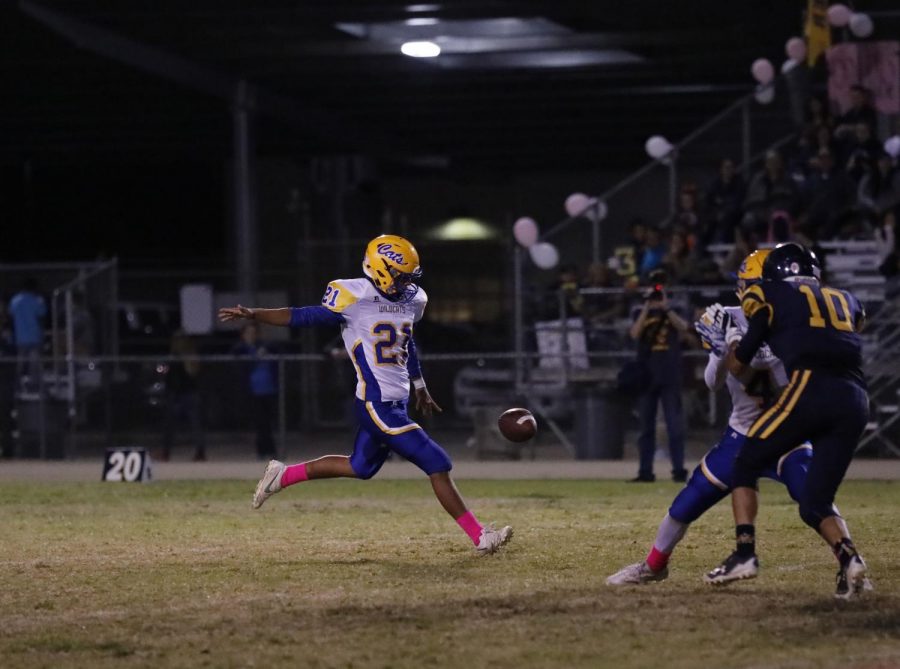 Number 21, Enrique Reyes, punting off to Shafter while Varsity defense covers him.