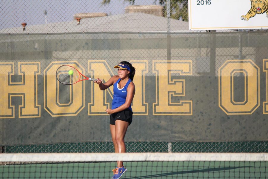 Brisa Guizar hitting the tennis ball back to Highland Scots. 