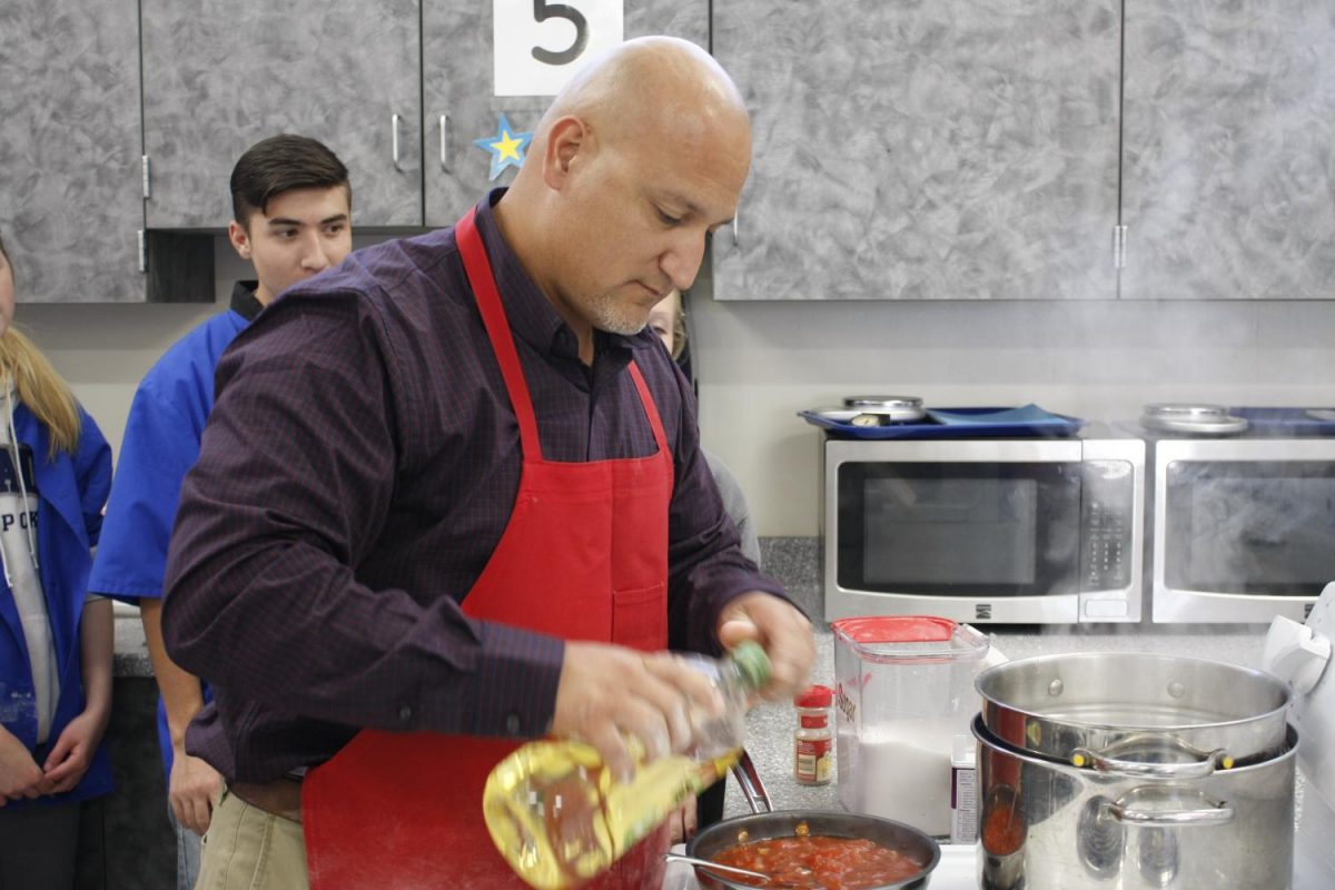 New Foods teacher, Mr. Chavira, helping a group of students prepare their sauce.