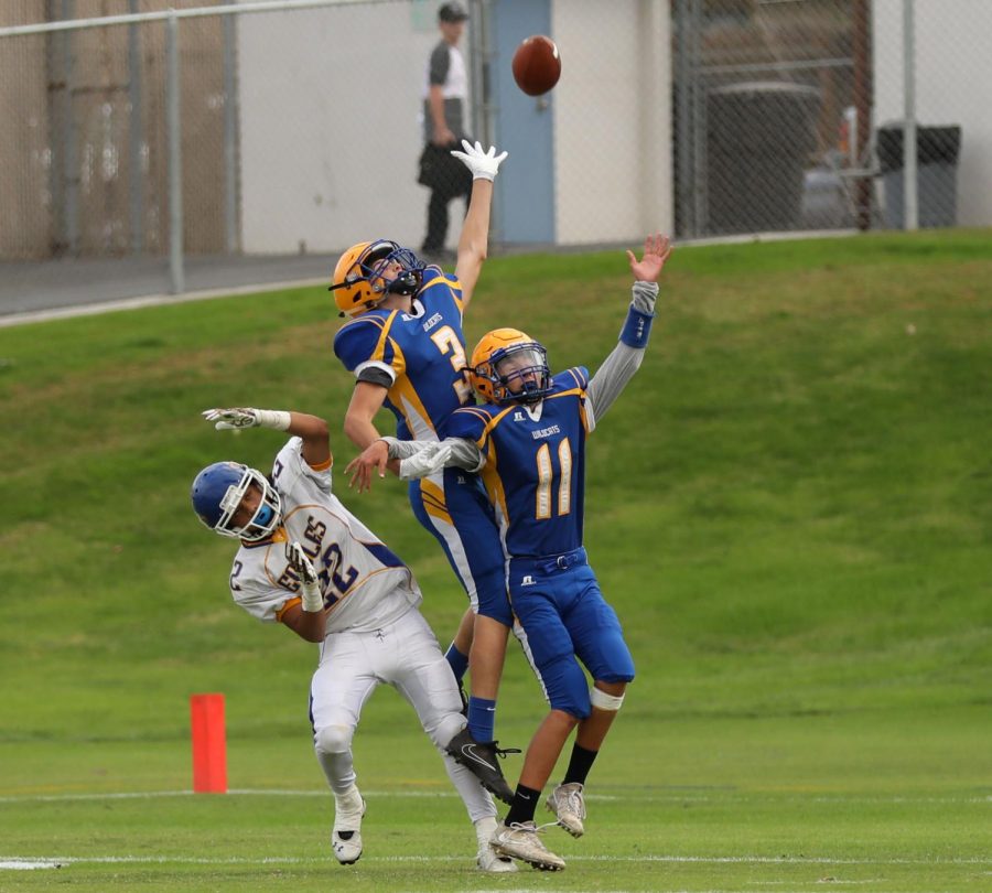No. 3 (Jonathan Hopkins) is seen leaping for the ball above No. 11 (Logan Rolin), in an attempt to intercept the ball from the Eagles.