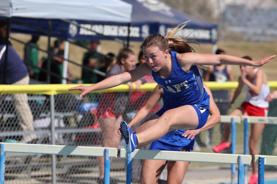Macayla competing in hurdles at the Wildcat Invitational.