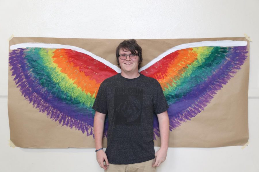 Barry Heimillier posing in front of the angel wings for Spring Fling.