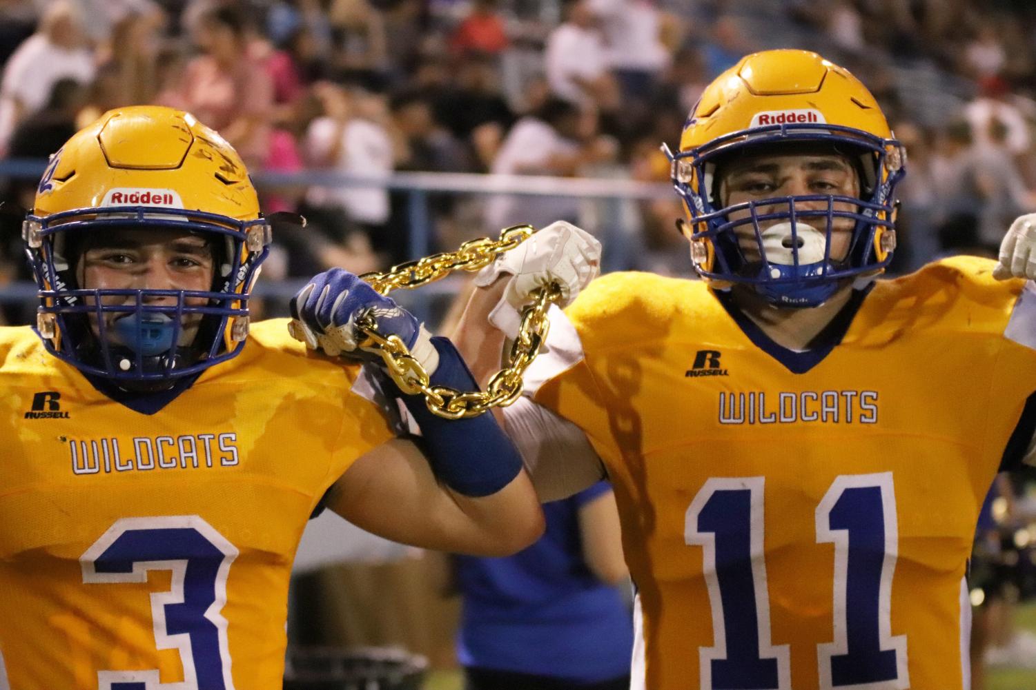 Big gains, Big chains. The team chain is raised with pride in between players Jordan Miranda (#3) and Alex Garcia (#11). Both players were able to run the ball into the end zone and lead the Wildcats to victory. The chain is seen as a fun reward that players get to wear after doing something big during the game.