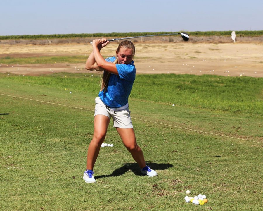 Macayla Wells practices with her hybrid on the driving range before the match. 
