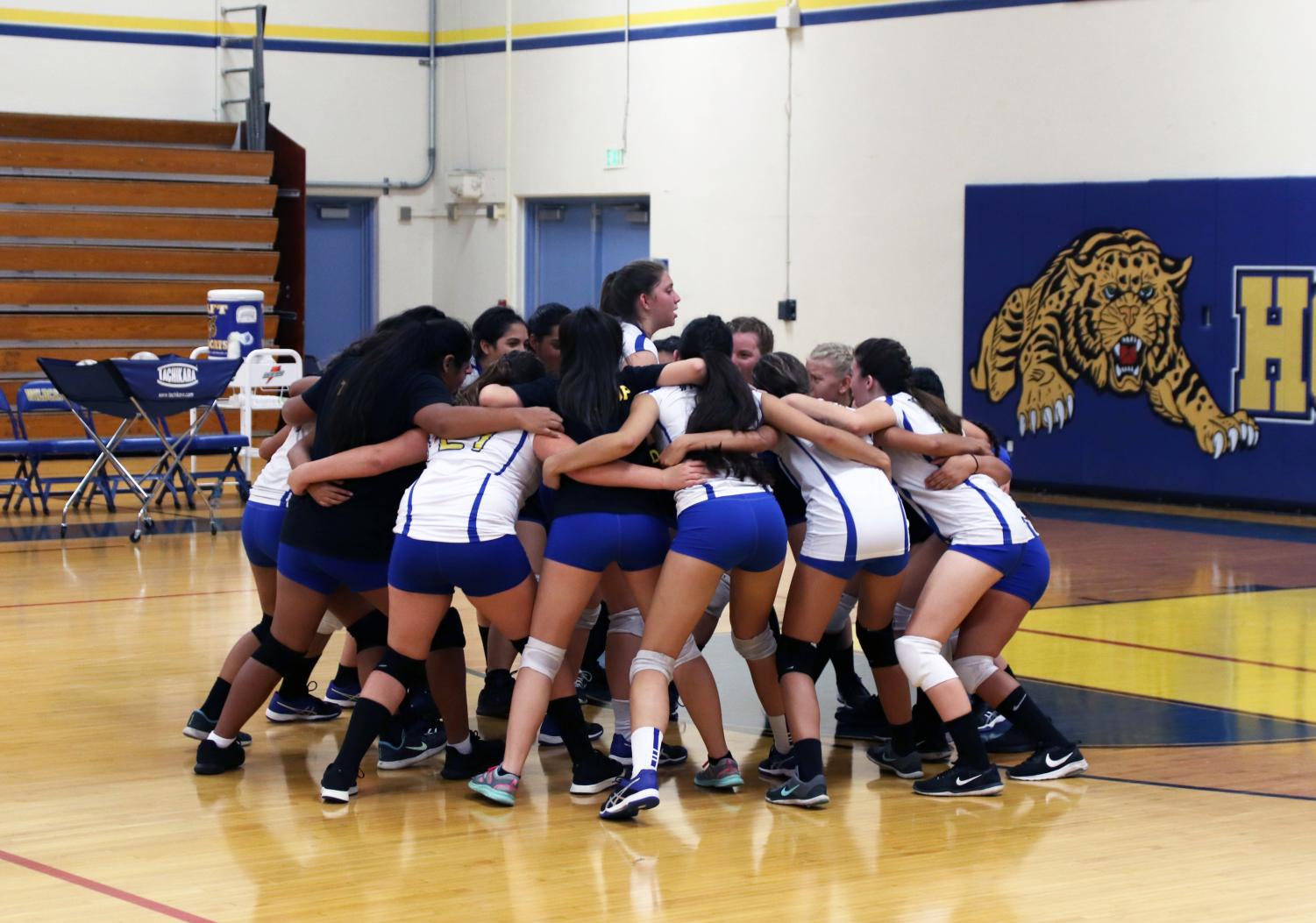 Teammates gather around in a huddle to celebrate their win. This was taken shortly after shaking hands with their opponents.