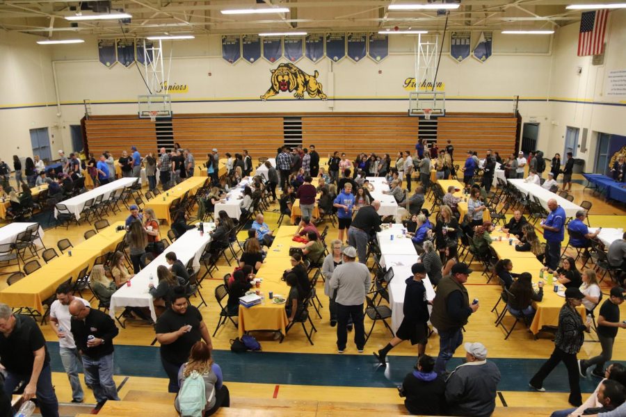 Family and friends gathered in Mullen gym having dinner provided by the Culinary Arts Club.