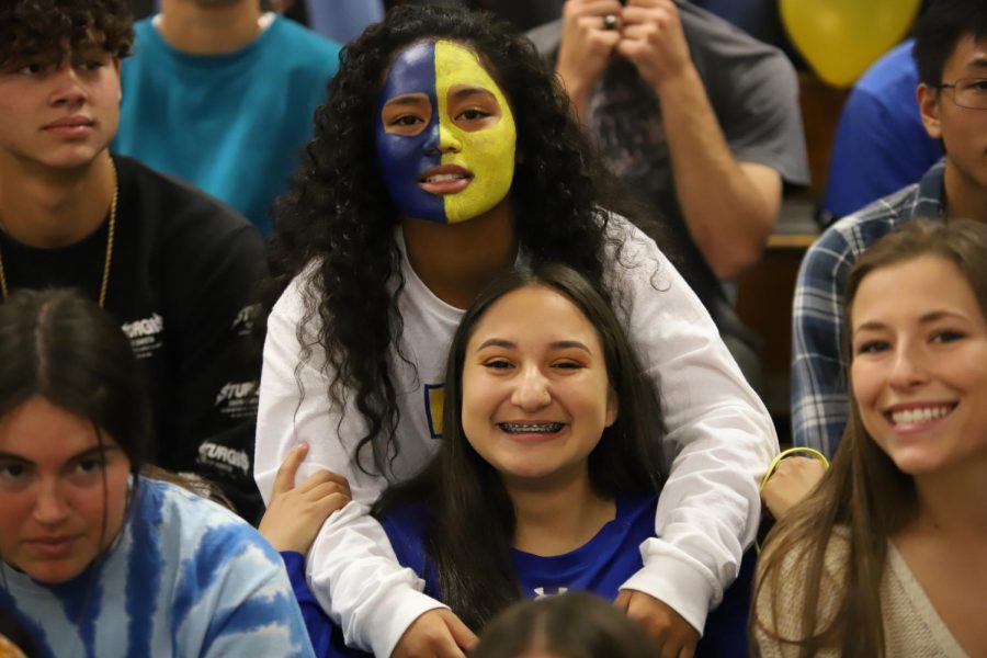 (Mariah Nevarez) Alana Iotamo and Adrianna Ramos smile for a photo at the homecoming rally. Alana showing off her school spirit with her gold and blue face. Adrianna with her blue braces and blue long sleeve shirt.