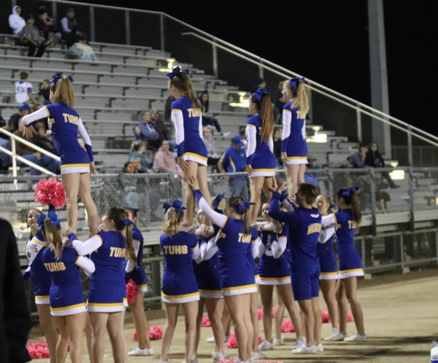 Varsity cheer team completing a stunt at the last away game during football season.  Most of the girls from the fall season enter competition cheer during the winter.