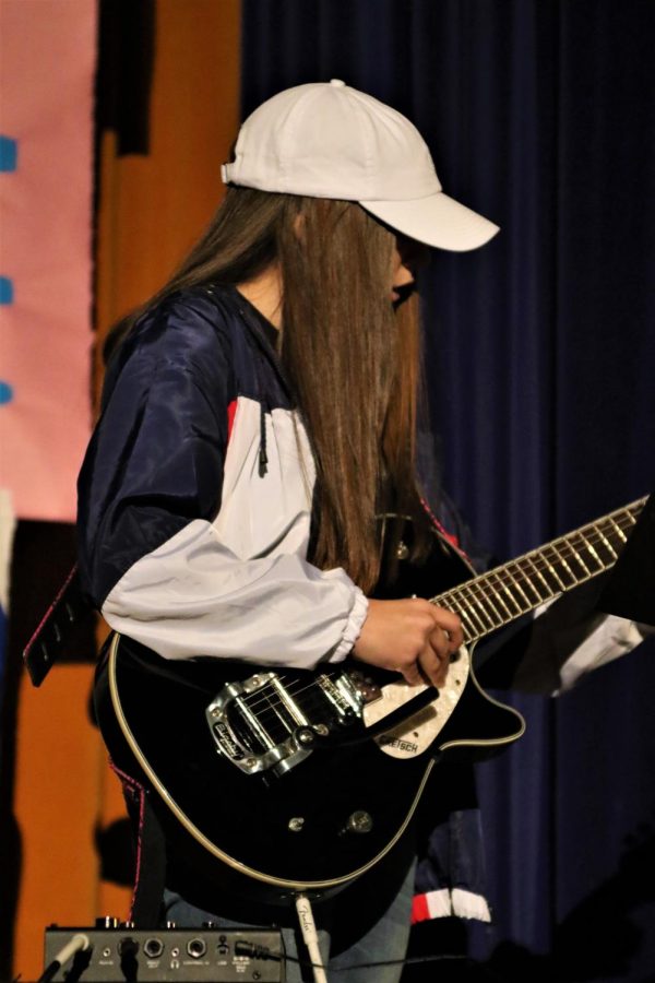 Callie White-Pittman playing the National Anthem on her guitar during the assembly.