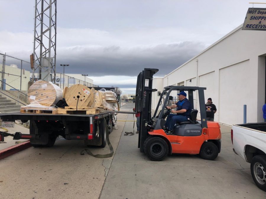 MOT employees unloading a truck while using a forklift.