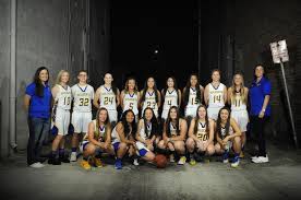Girls varisty basketball team posing for a great photo.