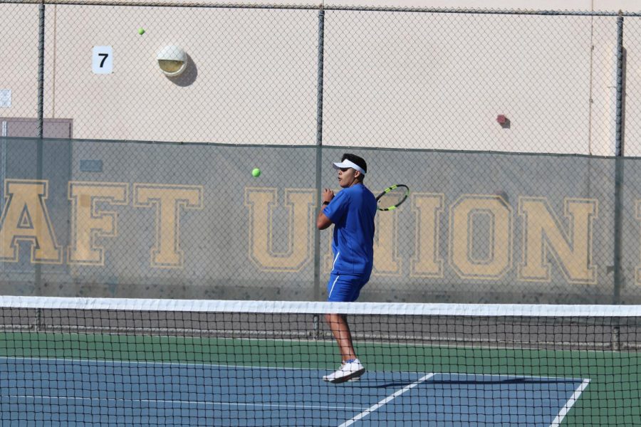 Senior tennis player, Juan Guerrero, returning the ball after a serve. He played a huge part on the tennis team winning the  S.S.L. title. 